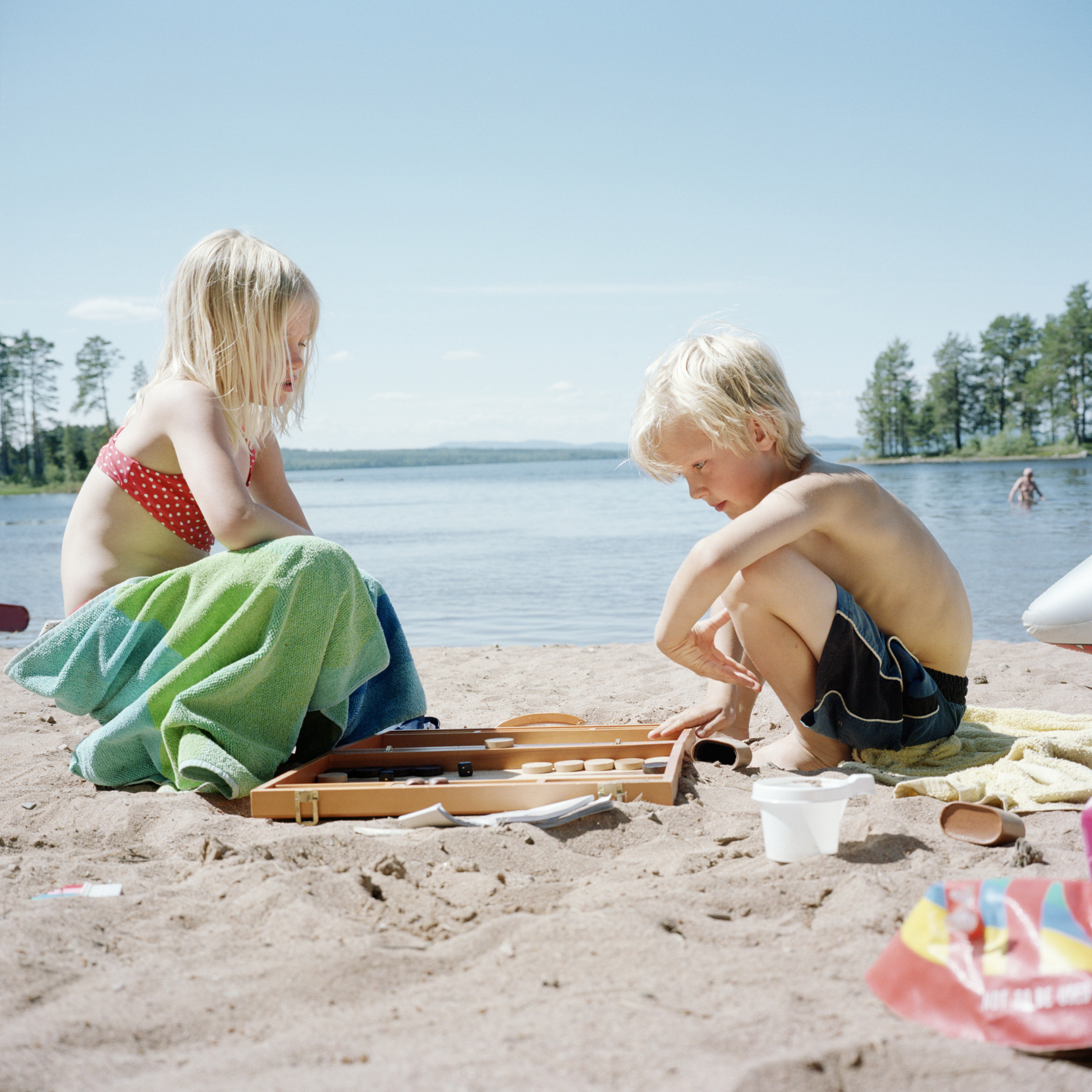 Két szőke gyerek játszik a strandon.