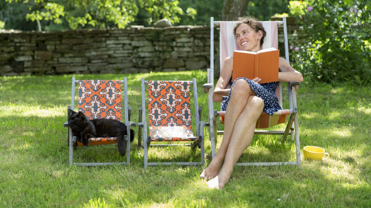 Hölgy nyugágyban könyvvel és cicával