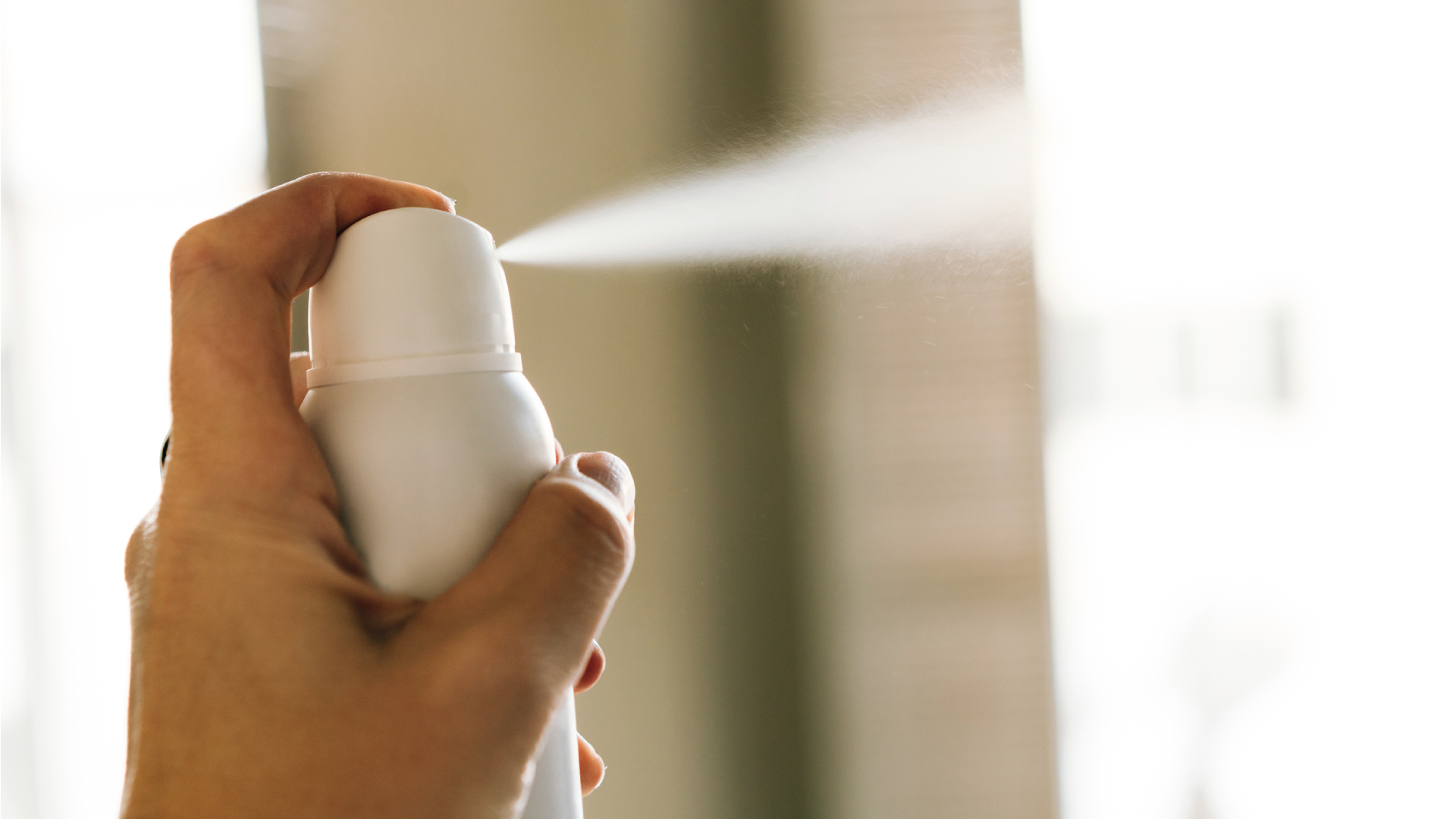 Közelről fotózott dezodor használat közben.