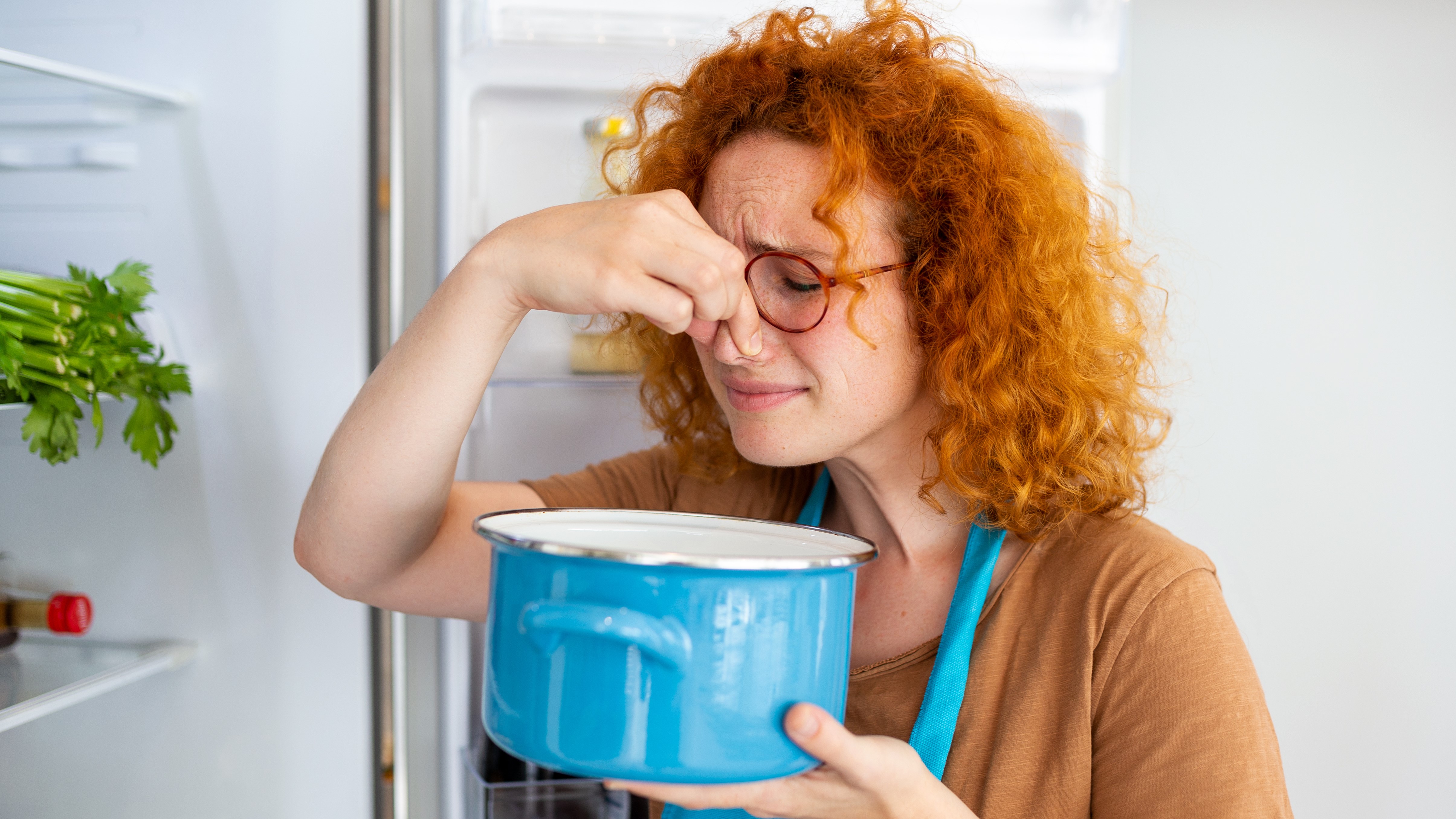 Egy nő romlott ételt szagol