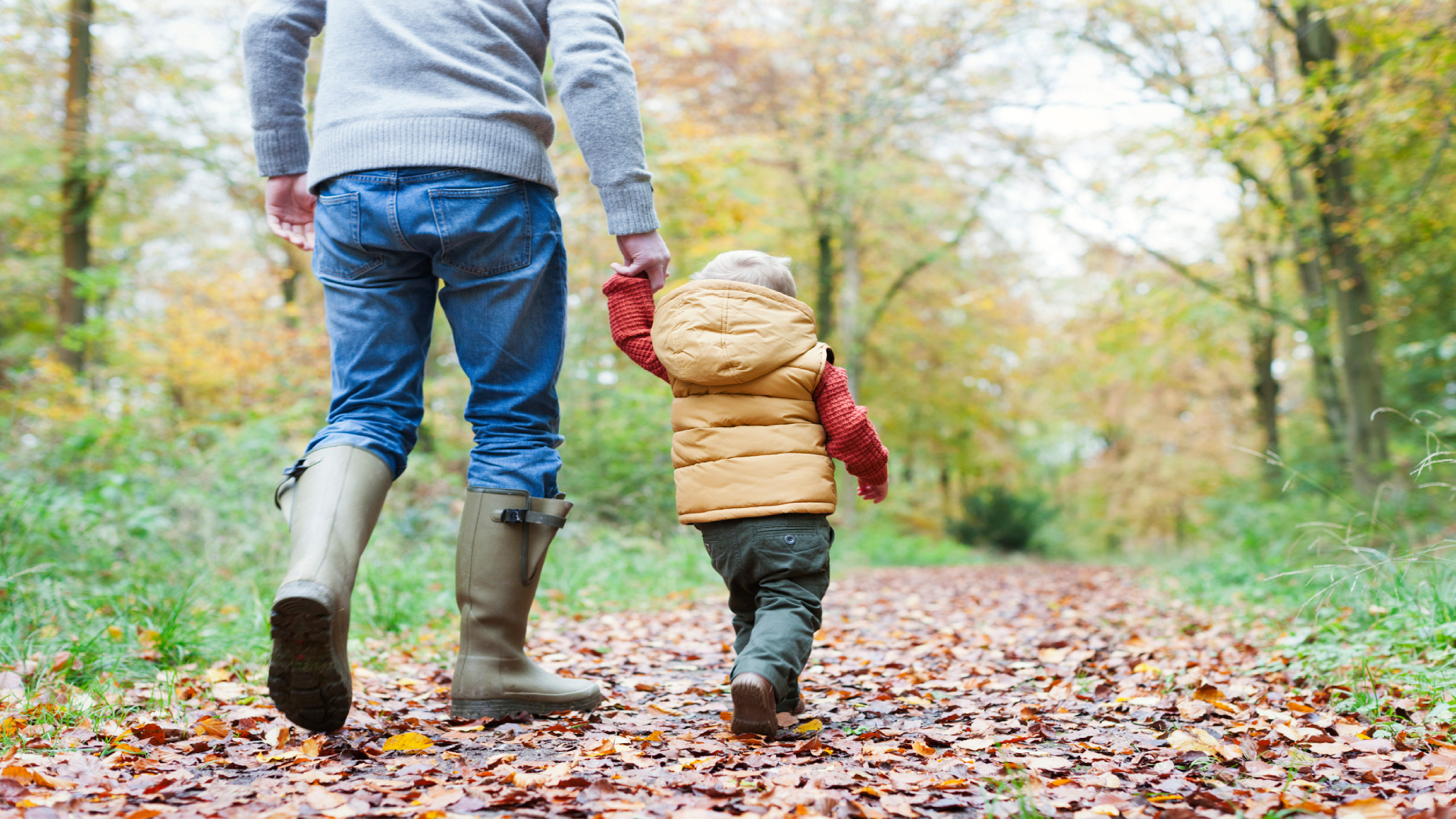 Gumicsizmában túrázó férfi és kisgyerek.