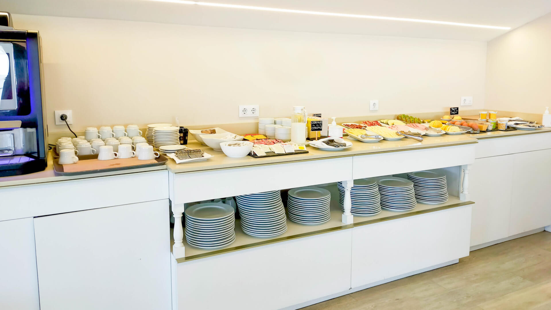 Tényérok és kontinentális reggeli felszolgálva egy pulton.