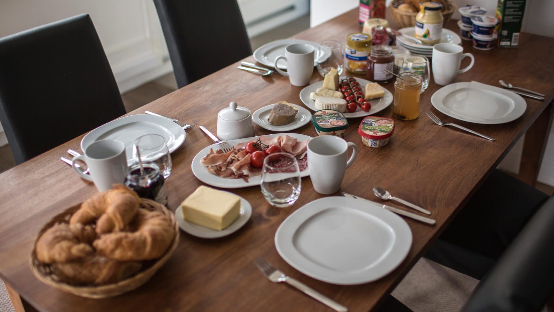 Megterített asztal, croissanttal, lekvárral, felvágottakkal.