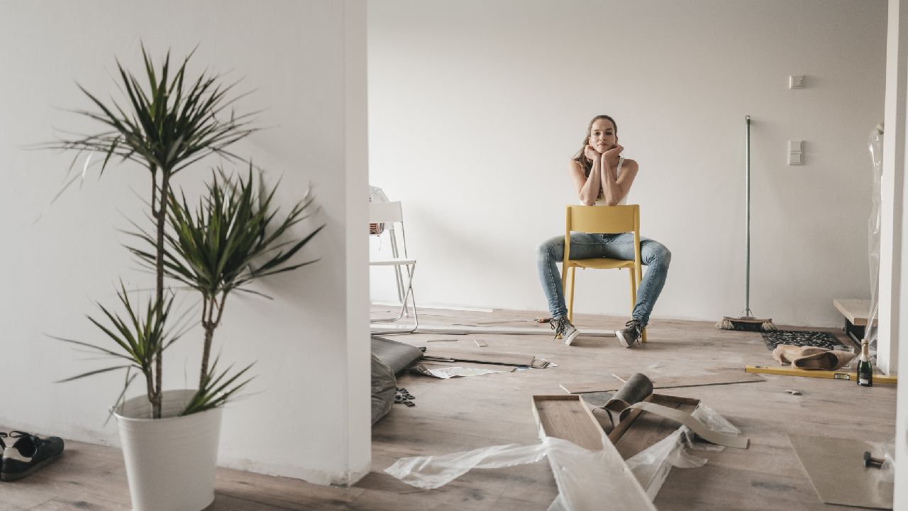 Nő ül egy széken lakásfelújítás közben