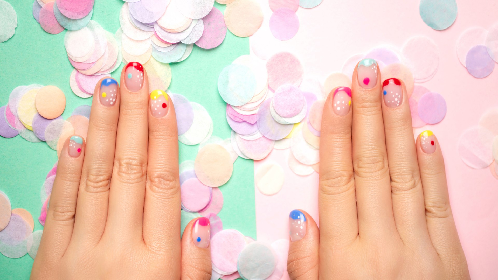 Színes francia manikűr színes háttér előtt.