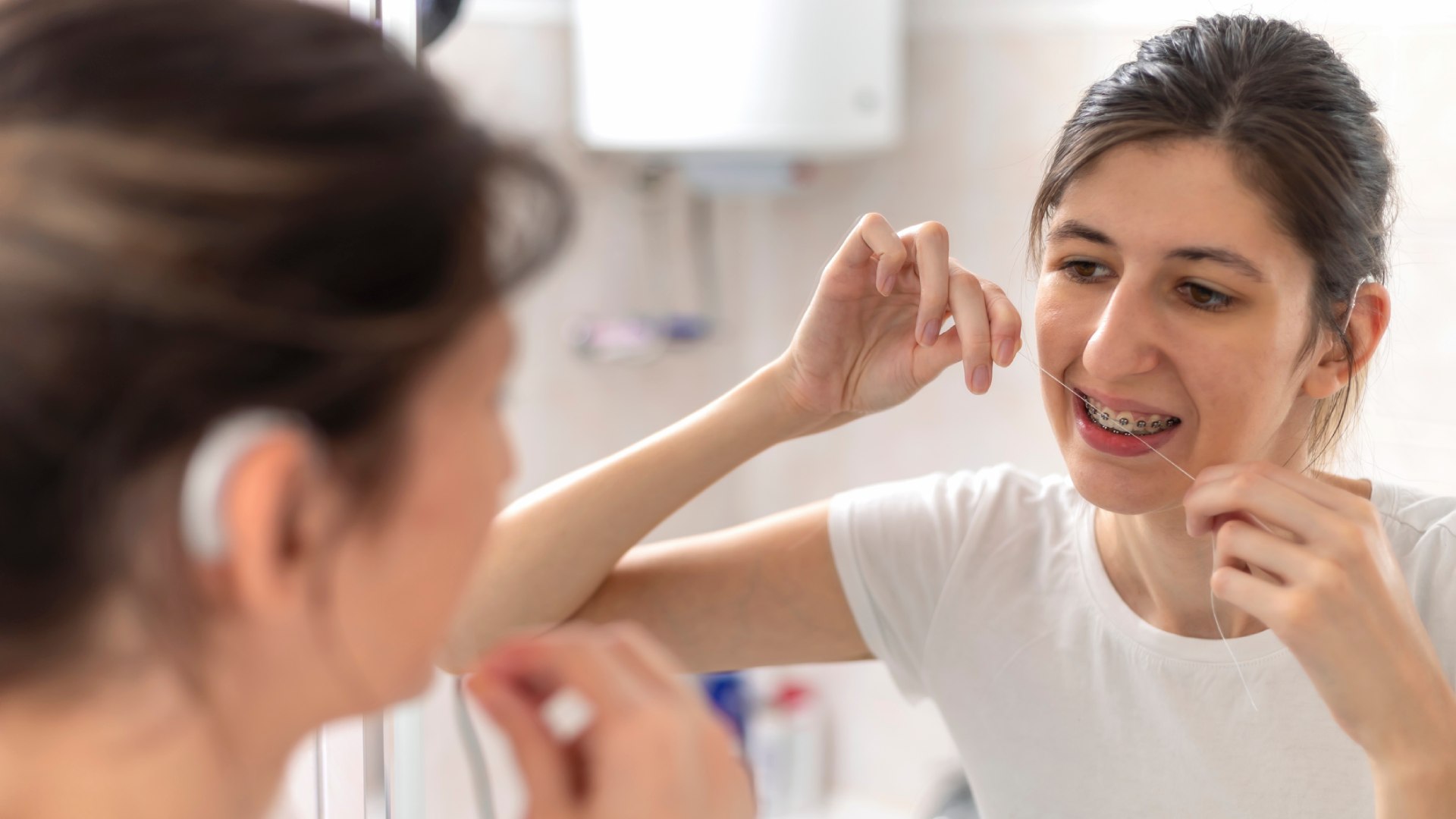 Fogselymet használó fogszabályozós nő.