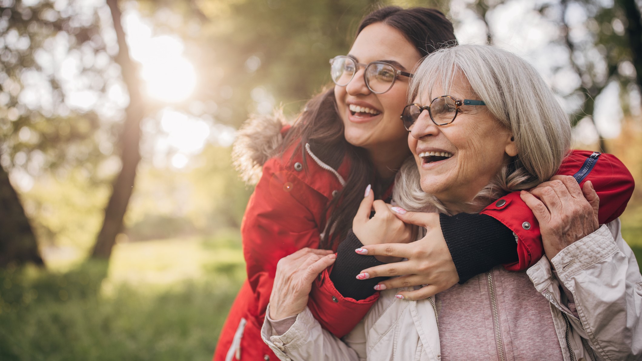 Egy fiatal és idős nő ölelkezik és nevet