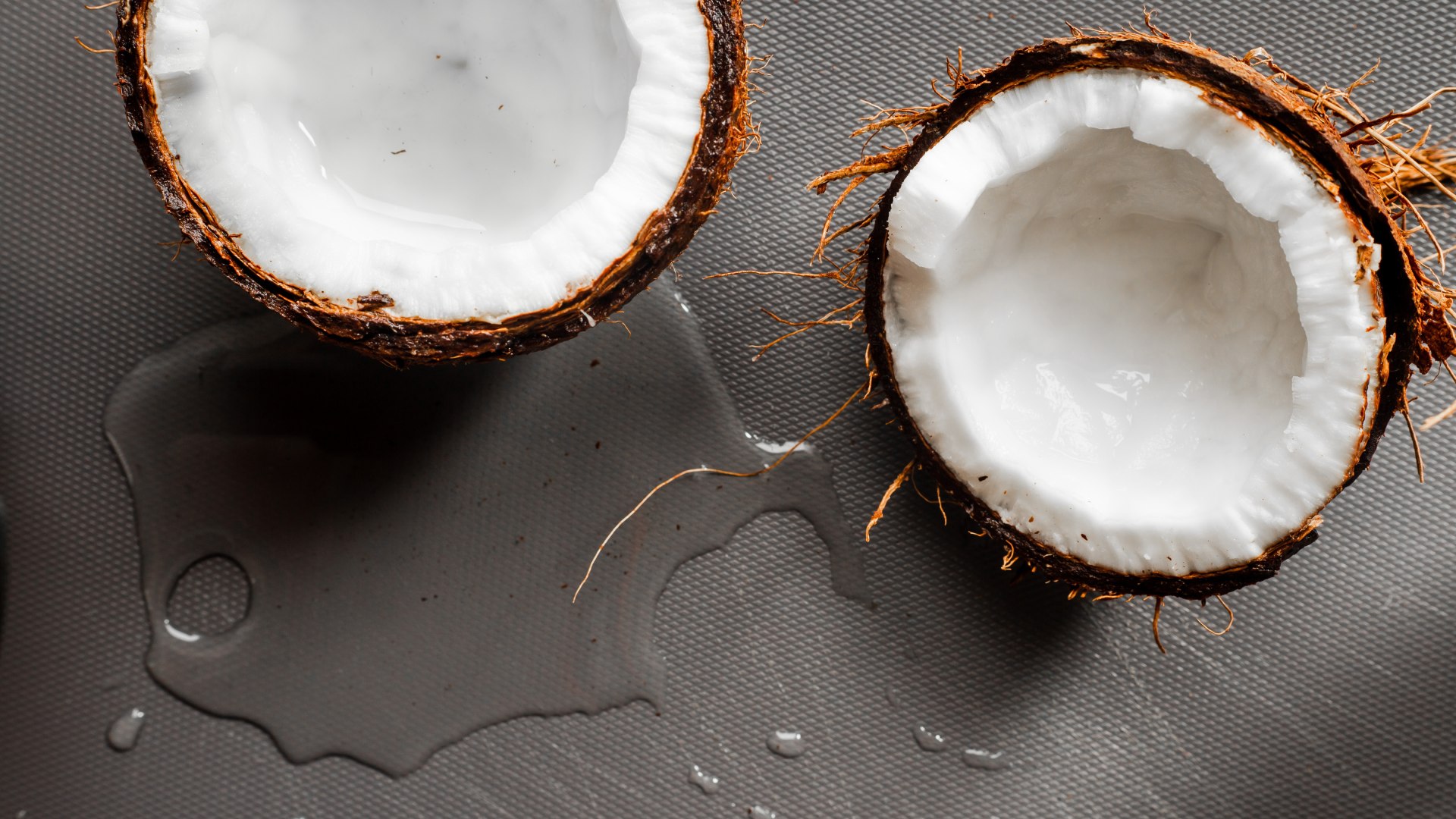 Félbevágott kókuszdió kiloccsant leve.