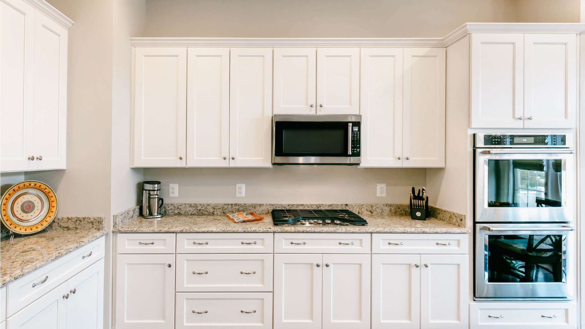 Mennyezetig érő, fehér konyhai szekrények.