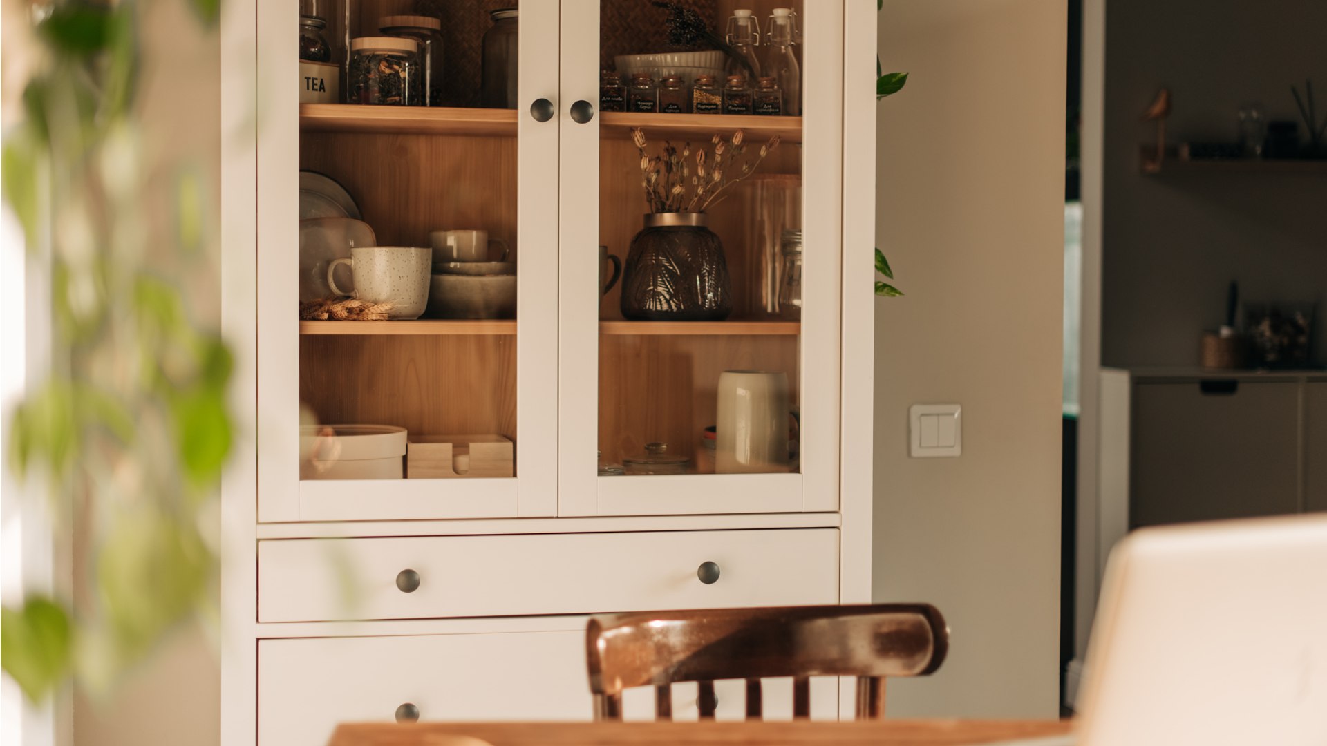 Fehér, üvegajtós szekrény.