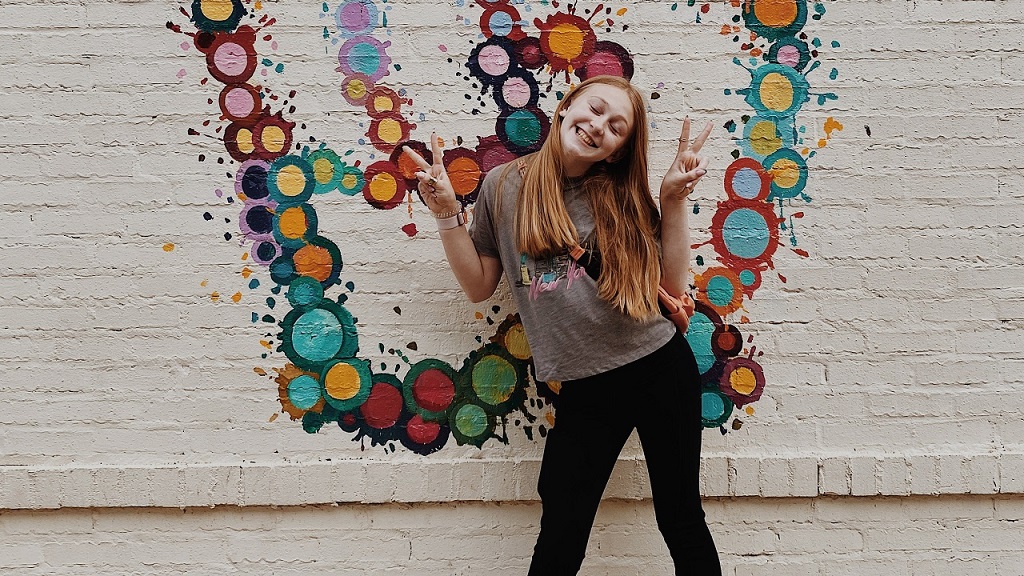 falfirka előtt pózoló tini