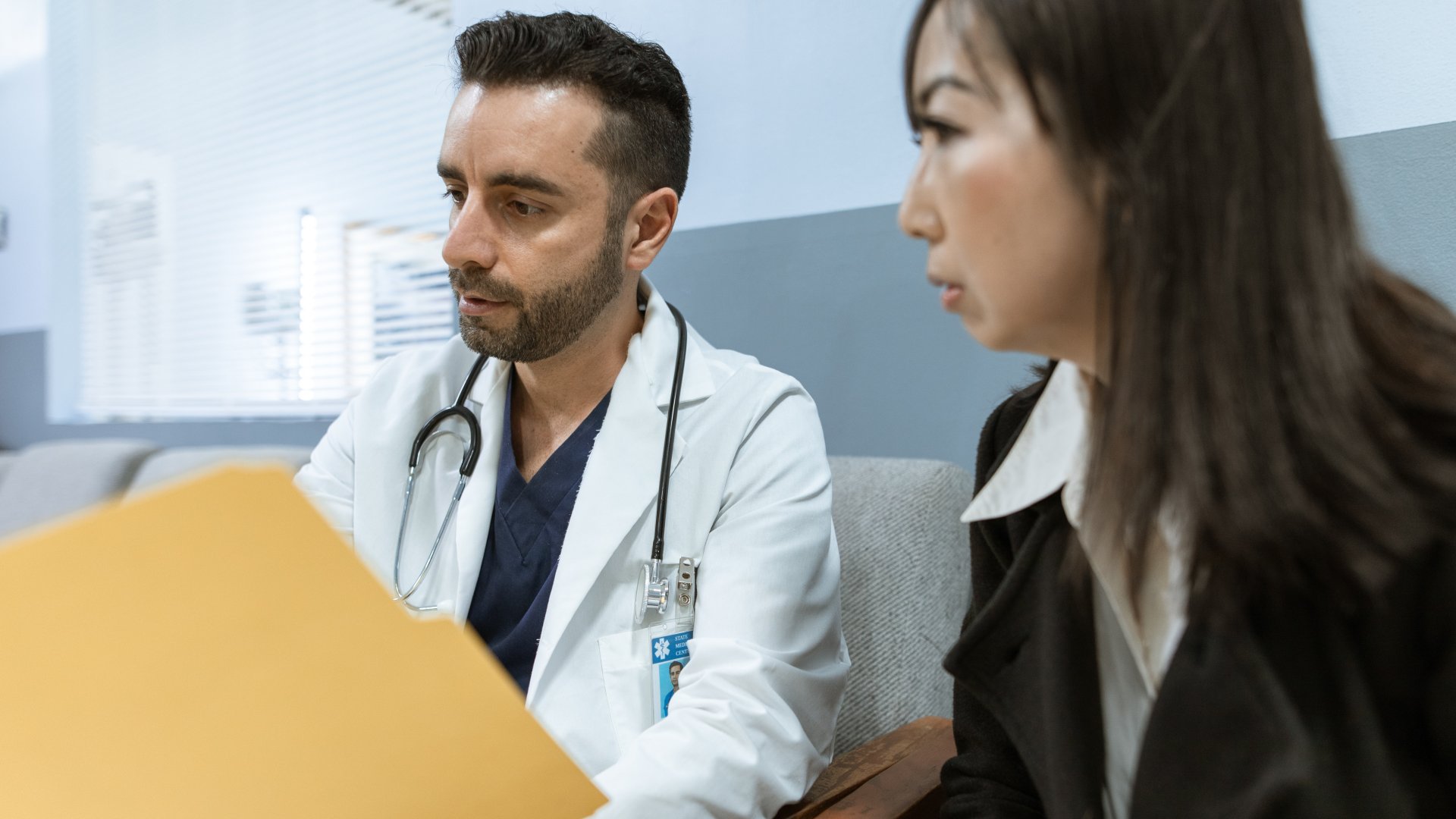 Egy férfi orvos és egy női beteg beszélget a folyosón