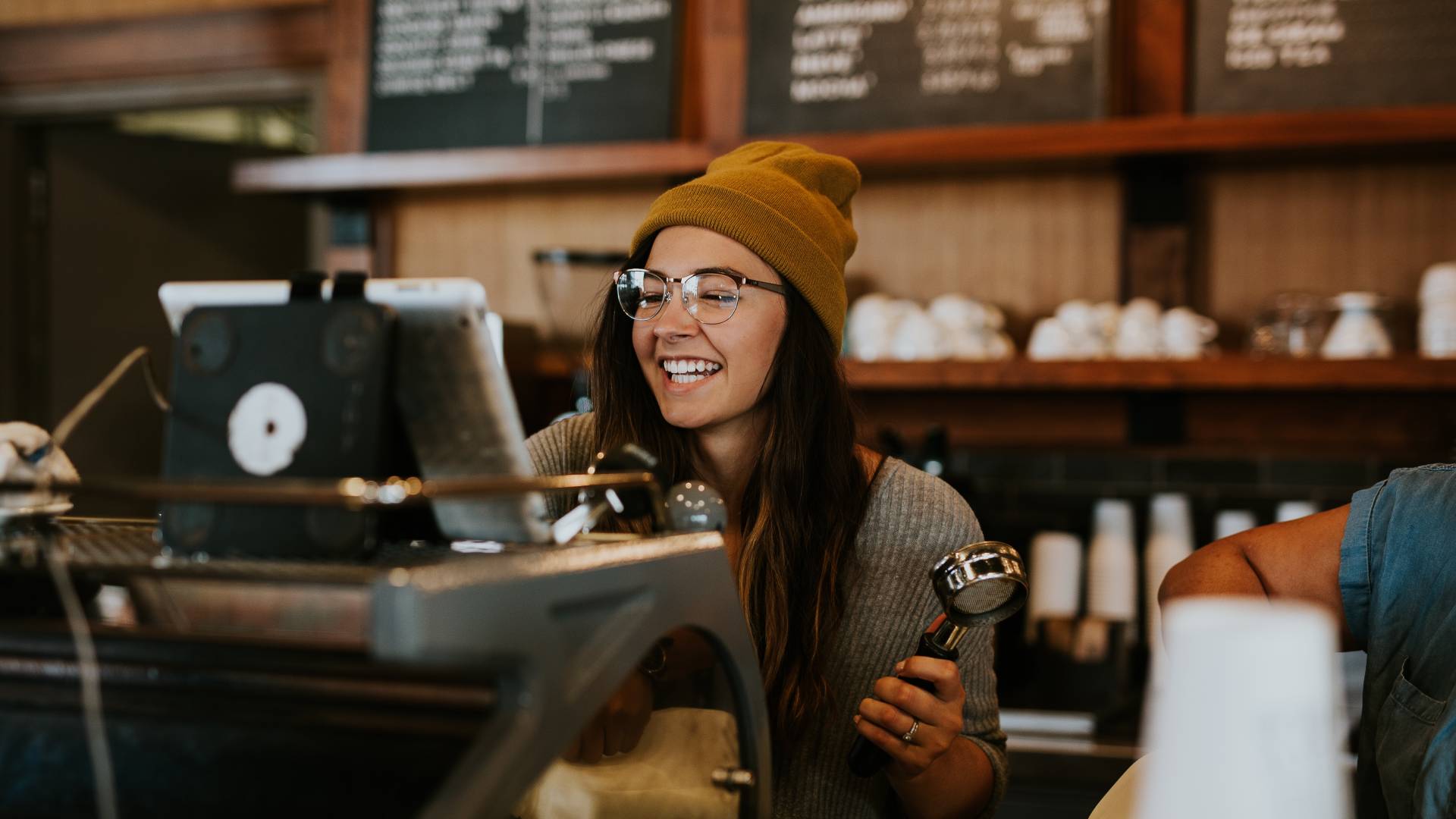 Pult mögött álló sapkás barista.