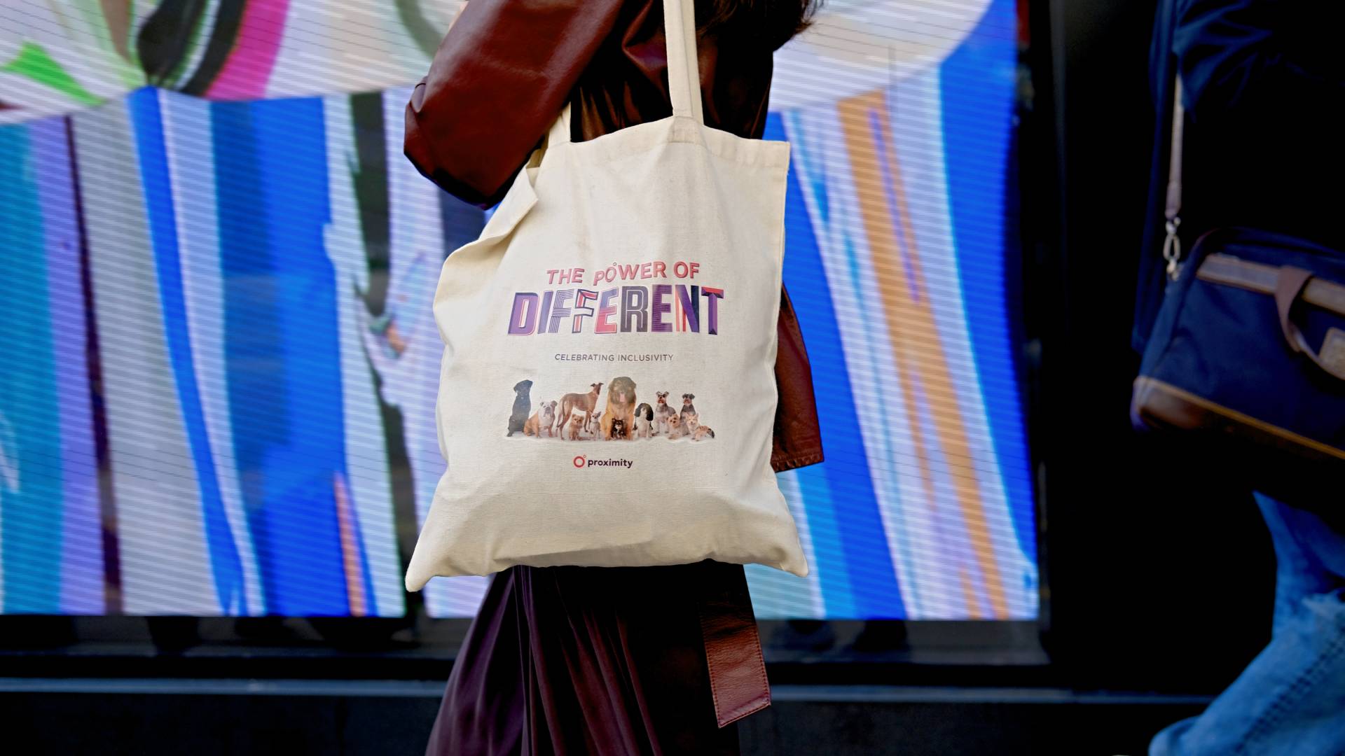 Feliratos vászontáskát viselő vörös kabátos nő.