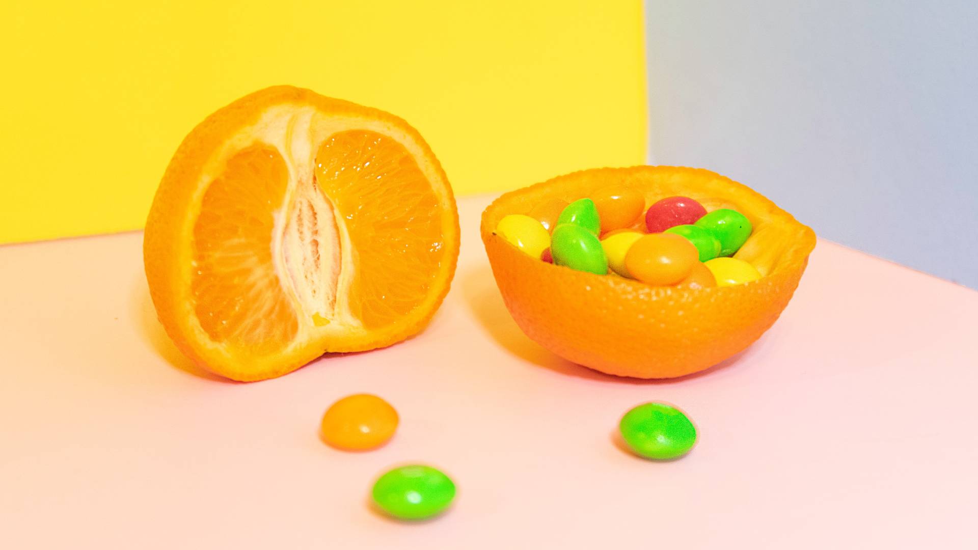 Félbevágott narancsok, az egyikben drazsék.