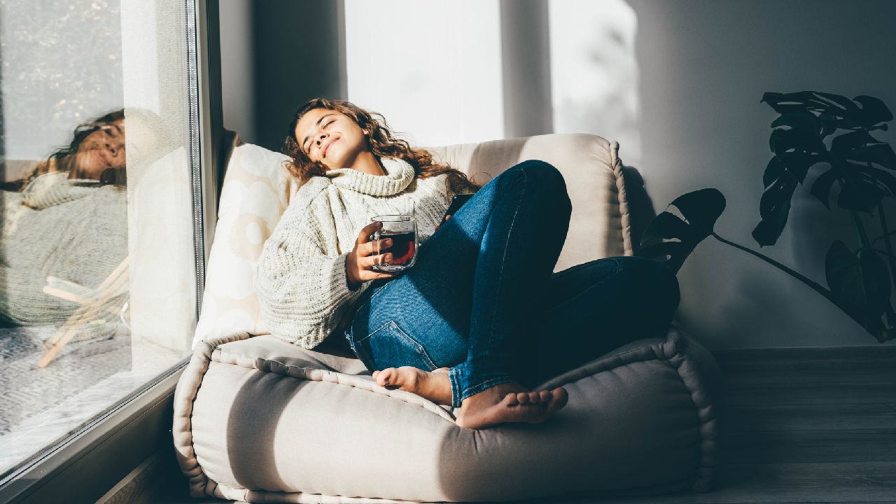 Nő napozik fotelben teázva