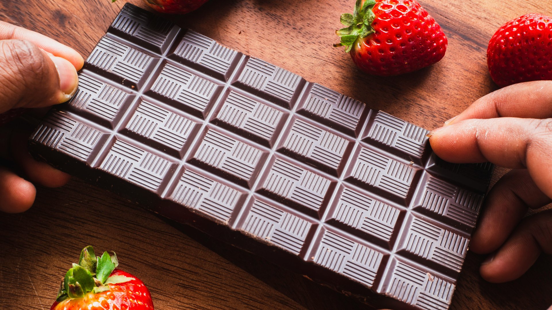 Egy tábla étcsokoládé pár szem eperrel.