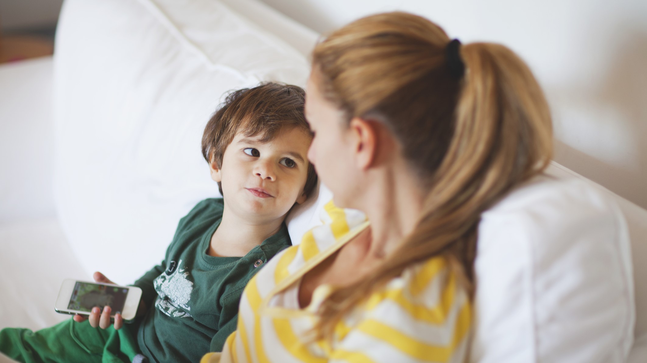 Édesanya fiával ül a kanapén