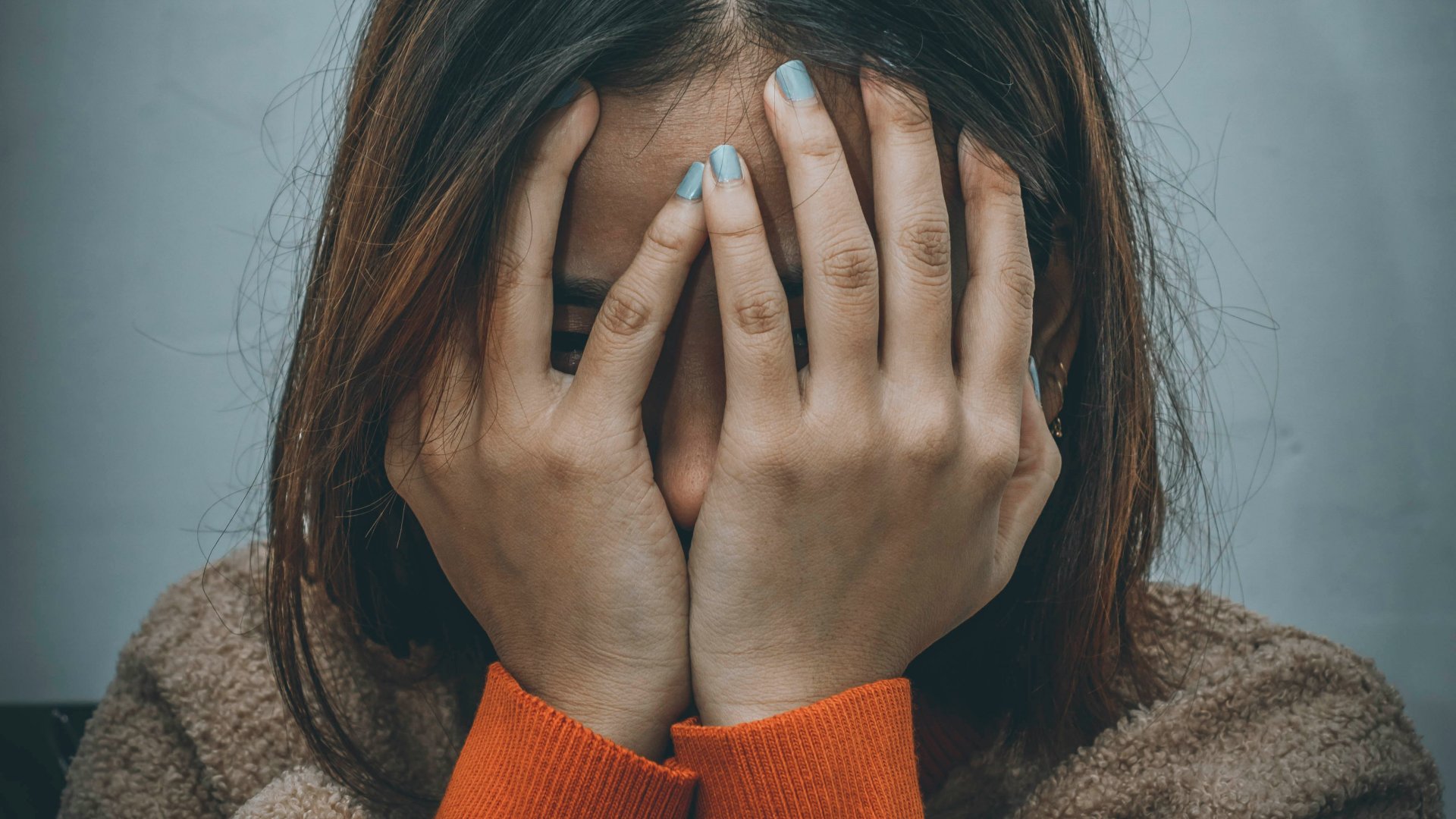 Egy nő a kezébe temeti az arcát