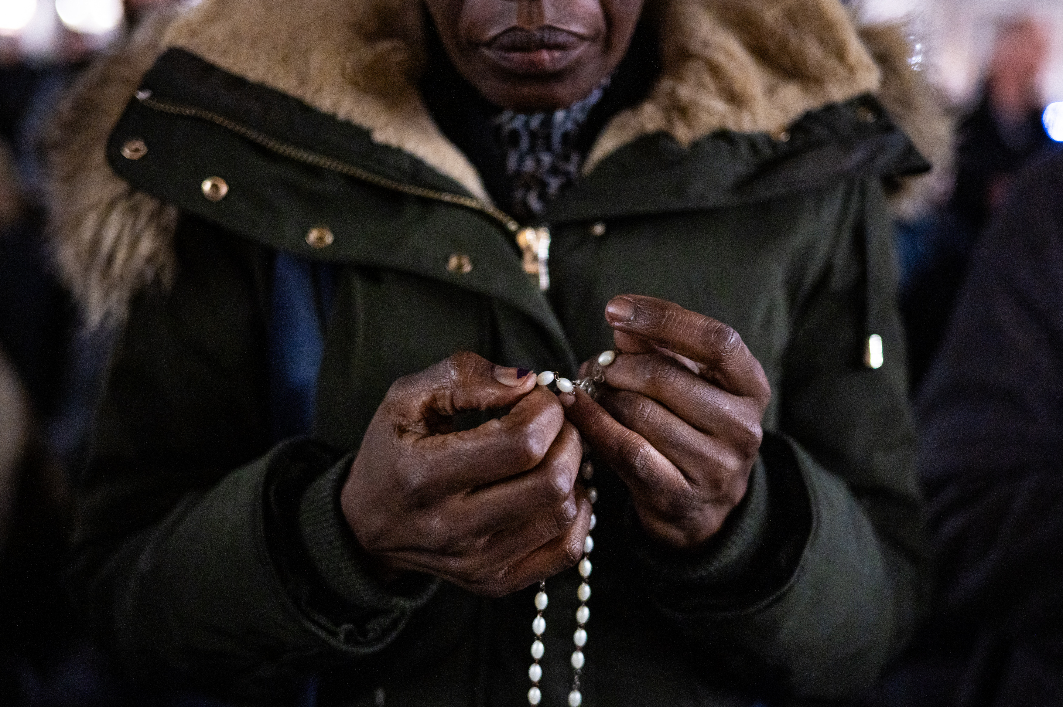 Nő morzsolja rózsafüzérét a Szent Péter téri közös ima előtt