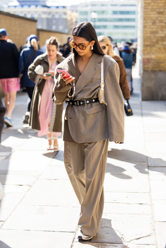 Oversize nadrágkosztümöt viselő nő az utcán