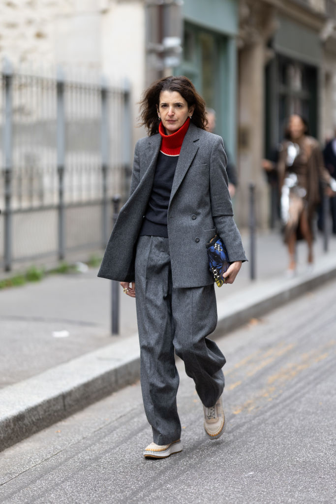 Oversize nadrágkosztümöt viselő nő az utcán