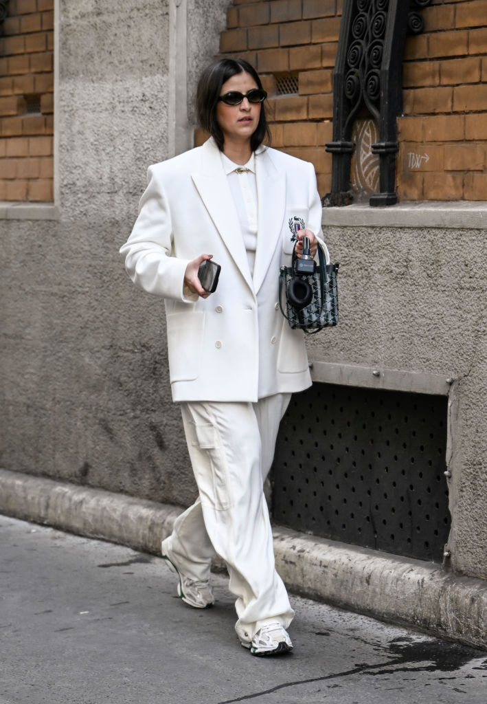 Oversize nadrágkosztümöt viselő nő az utcán