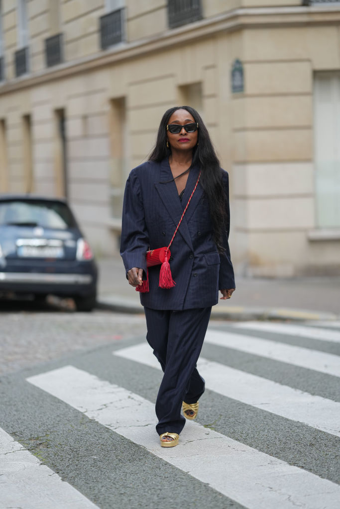 Oversize nadrágkosztümöt viselő nő az utcán
