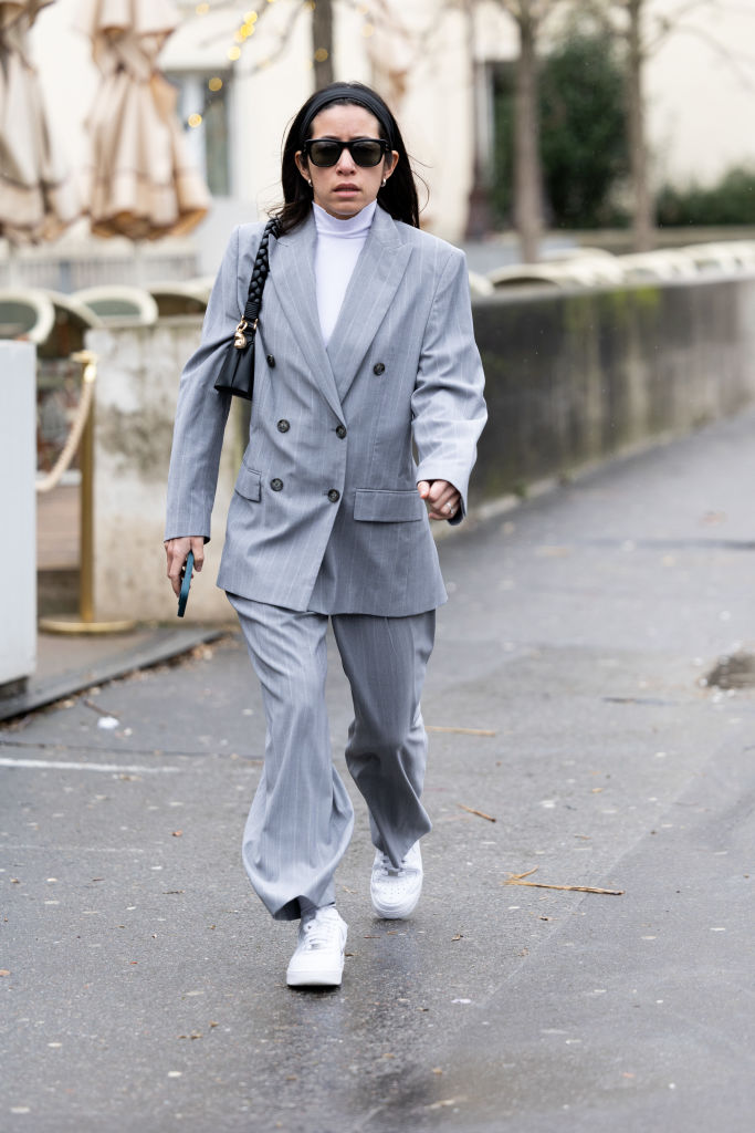 Oversize nadrágkosztümöt viselő nő az utcán