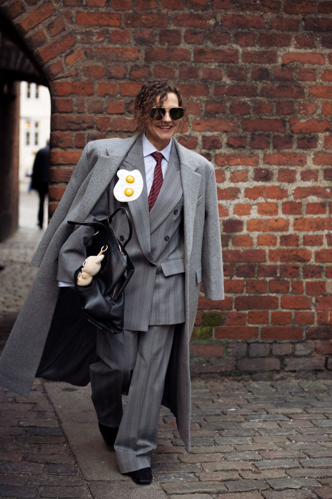 Oversize nadrágkosztümöt viselő nő az utcán