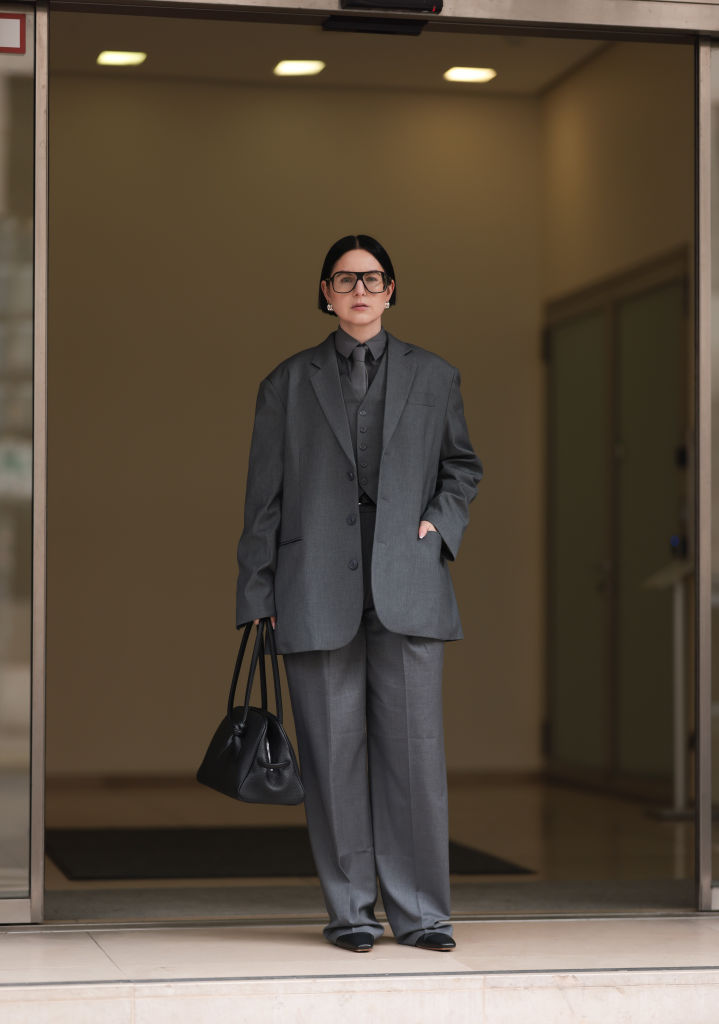 Oversize nadrágkosztümöt viselő nő az utcán