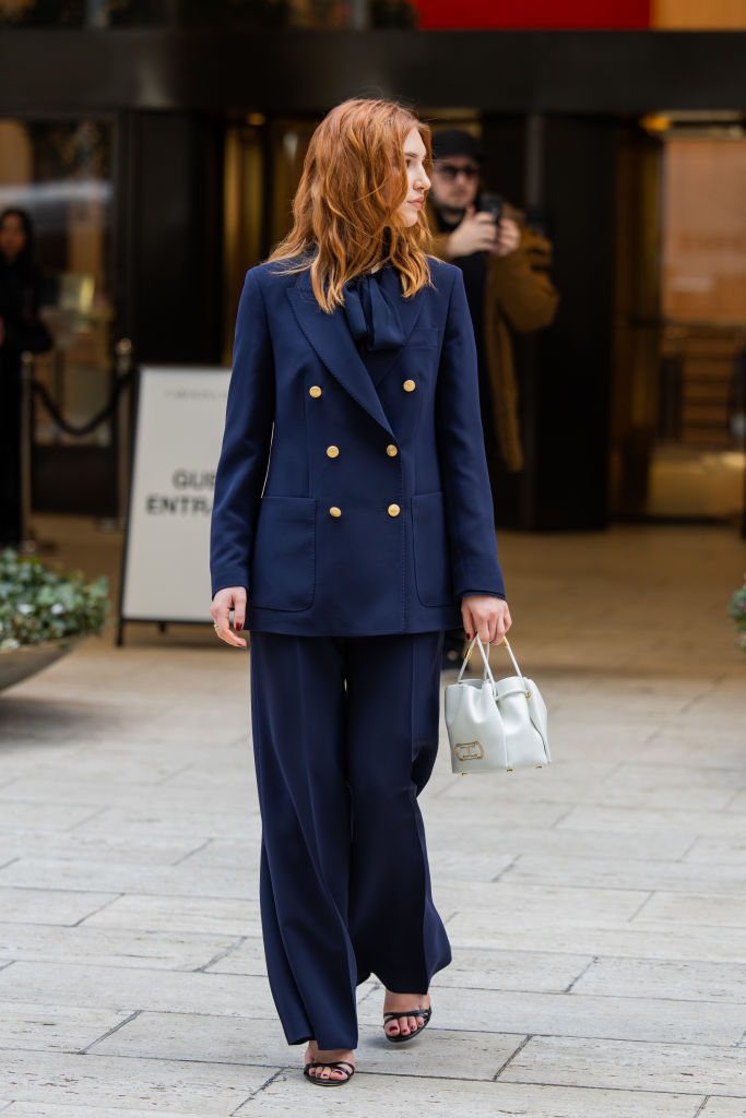 Oversize nadrágkosztümöt viselő nő az utcán