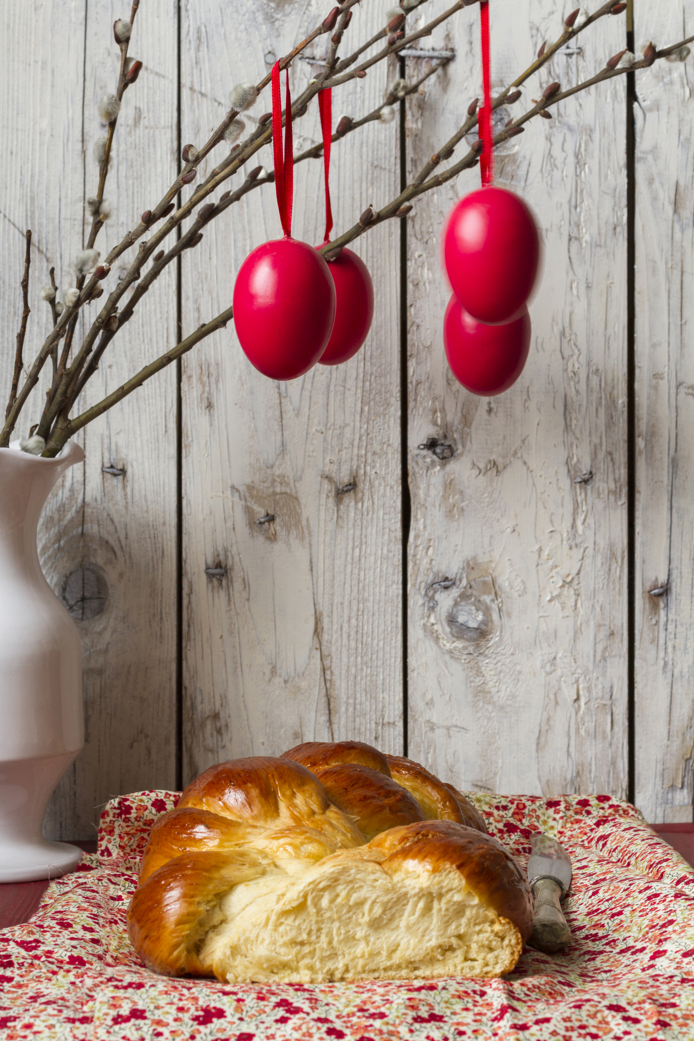 Barkaágról lógó piros húsvéti tojások