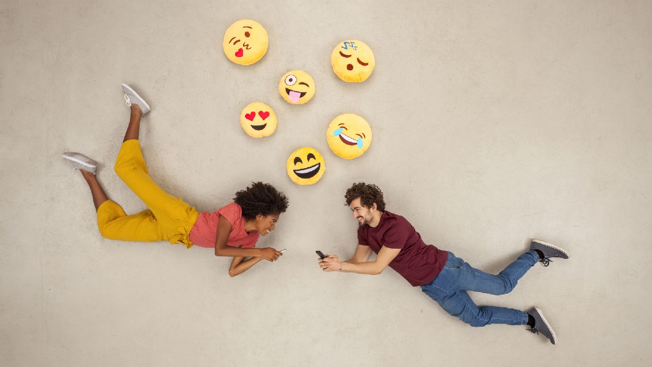 Férfi és nő beszélget lebegve emotikonokkal