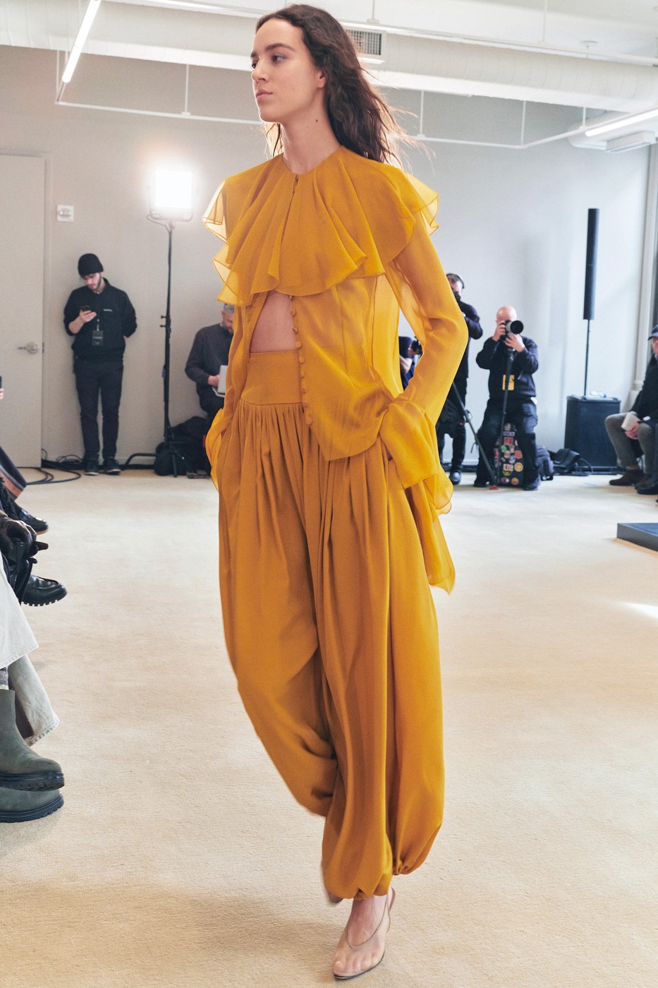 Modell a kifutón mustárszínű ruhában