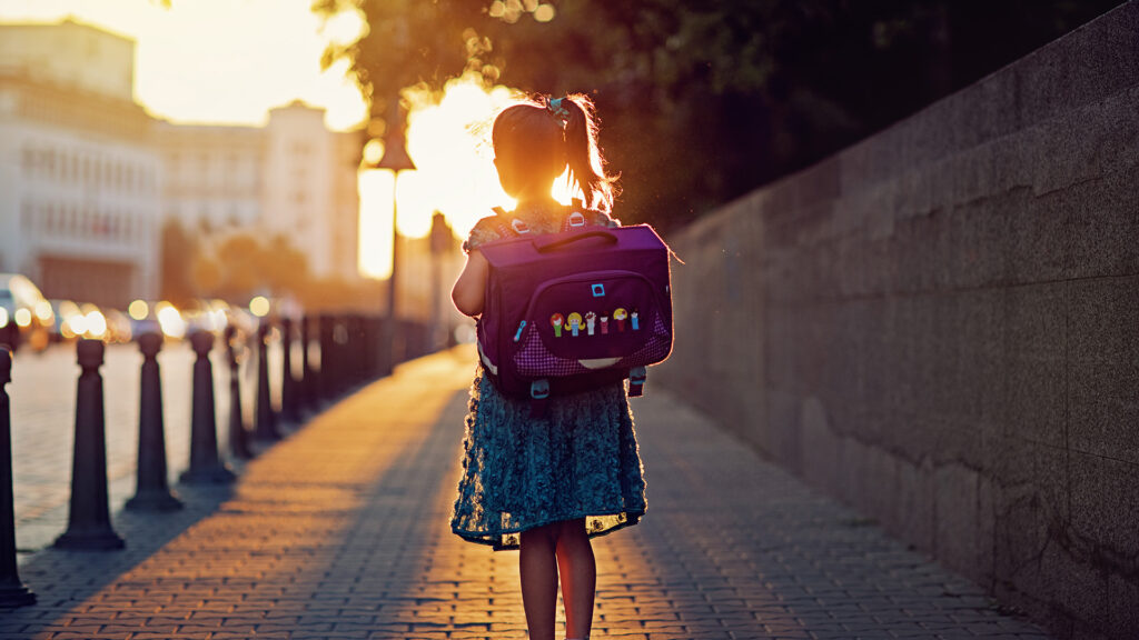 Kislány iskolatáskával sétál