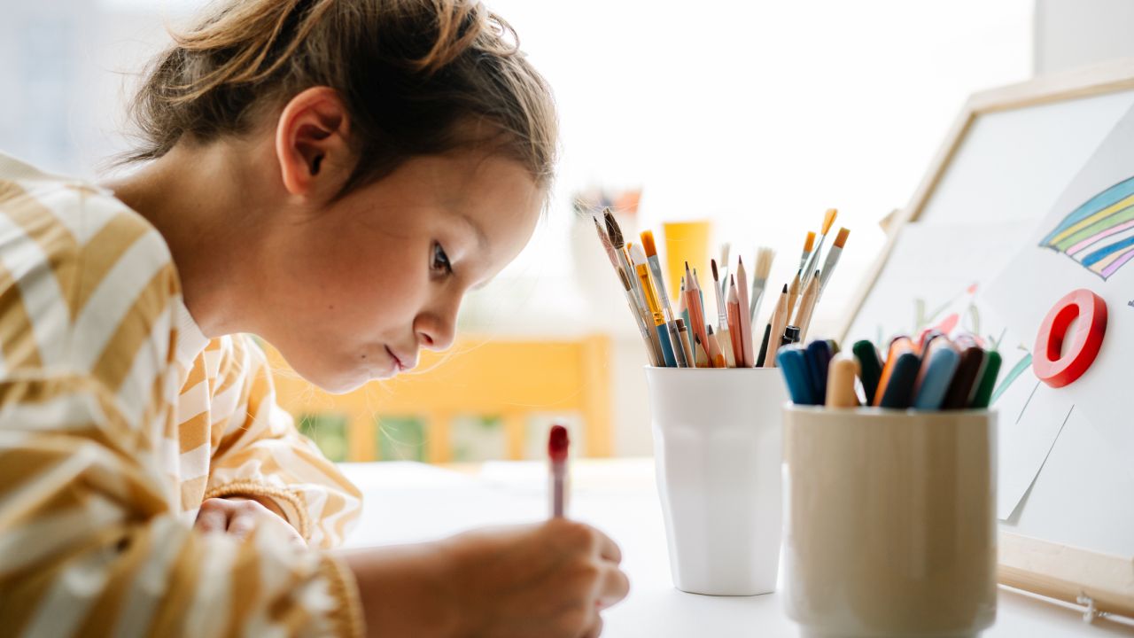 Kislány koncentrálva rajzol