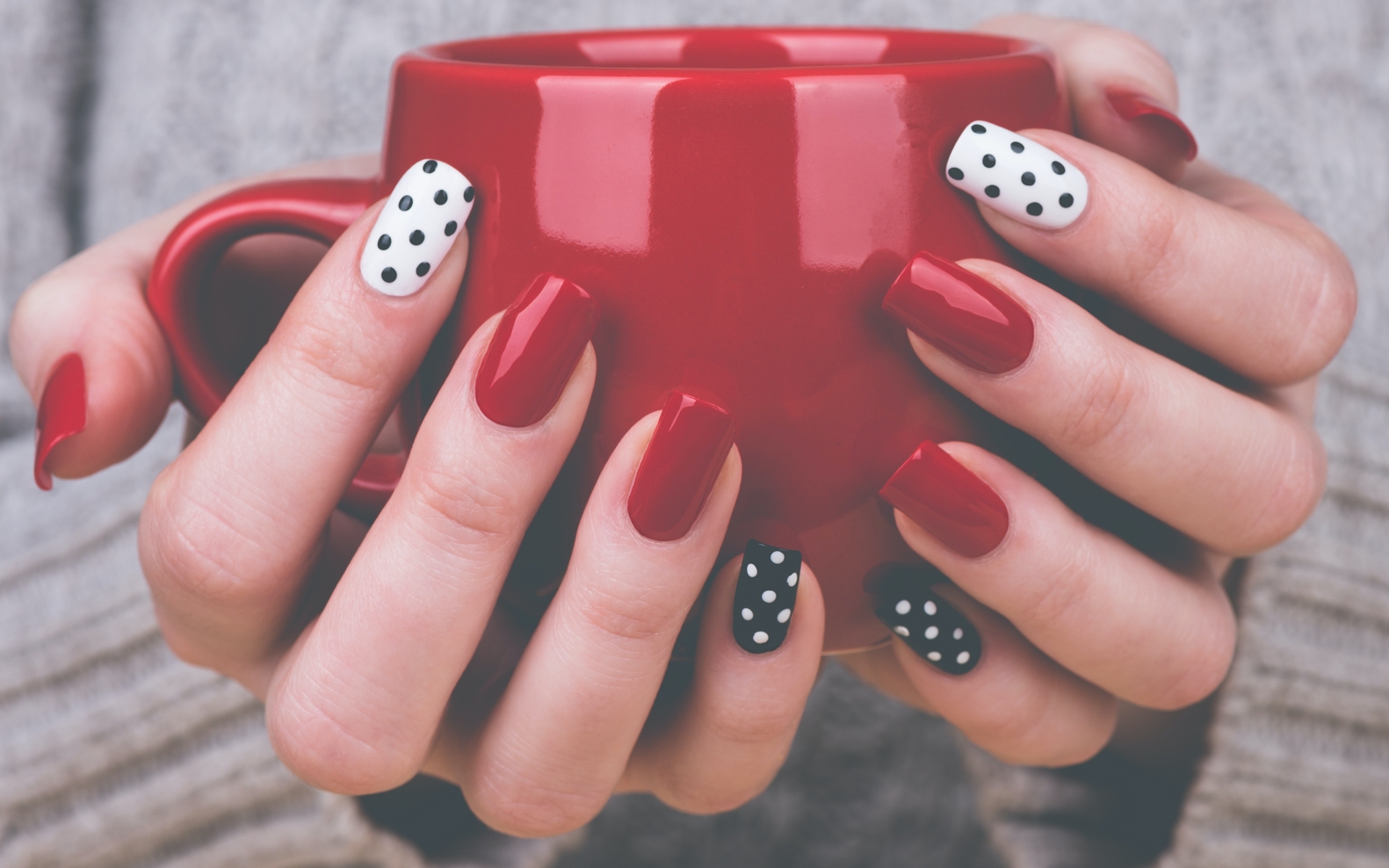 Nők kéz pöttyös manikűrrel, közelről