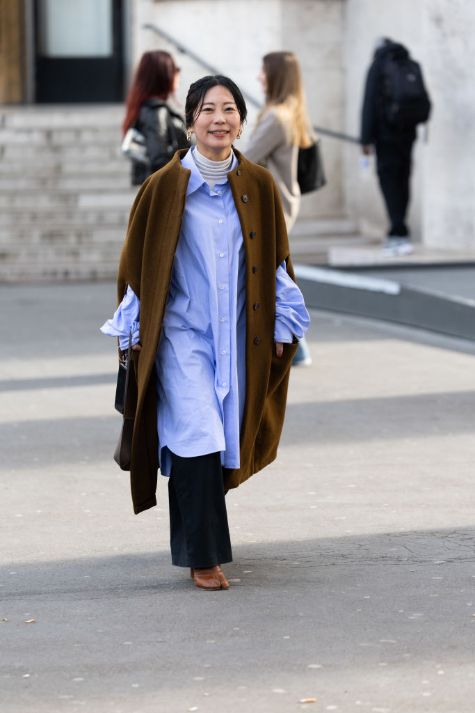 Barna-kék kombinációt viselő nő az utcán