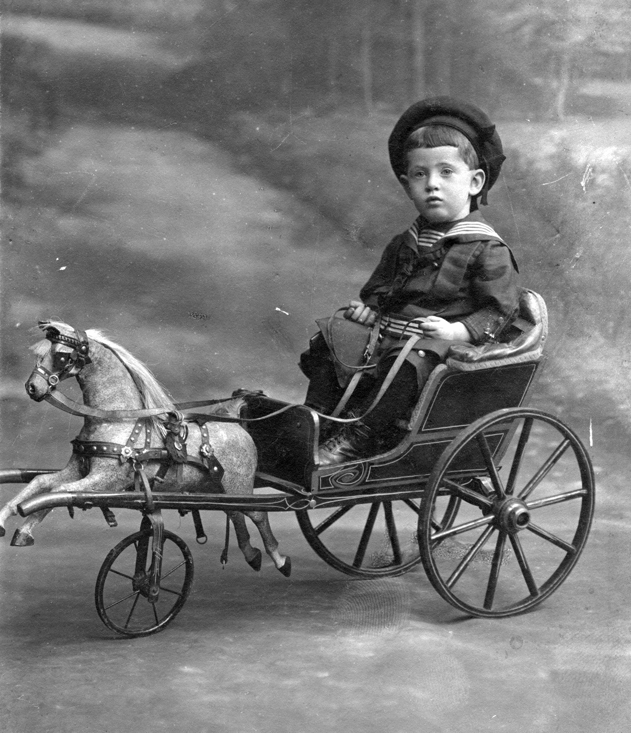 Kisfiú játékhintón 1900-ban