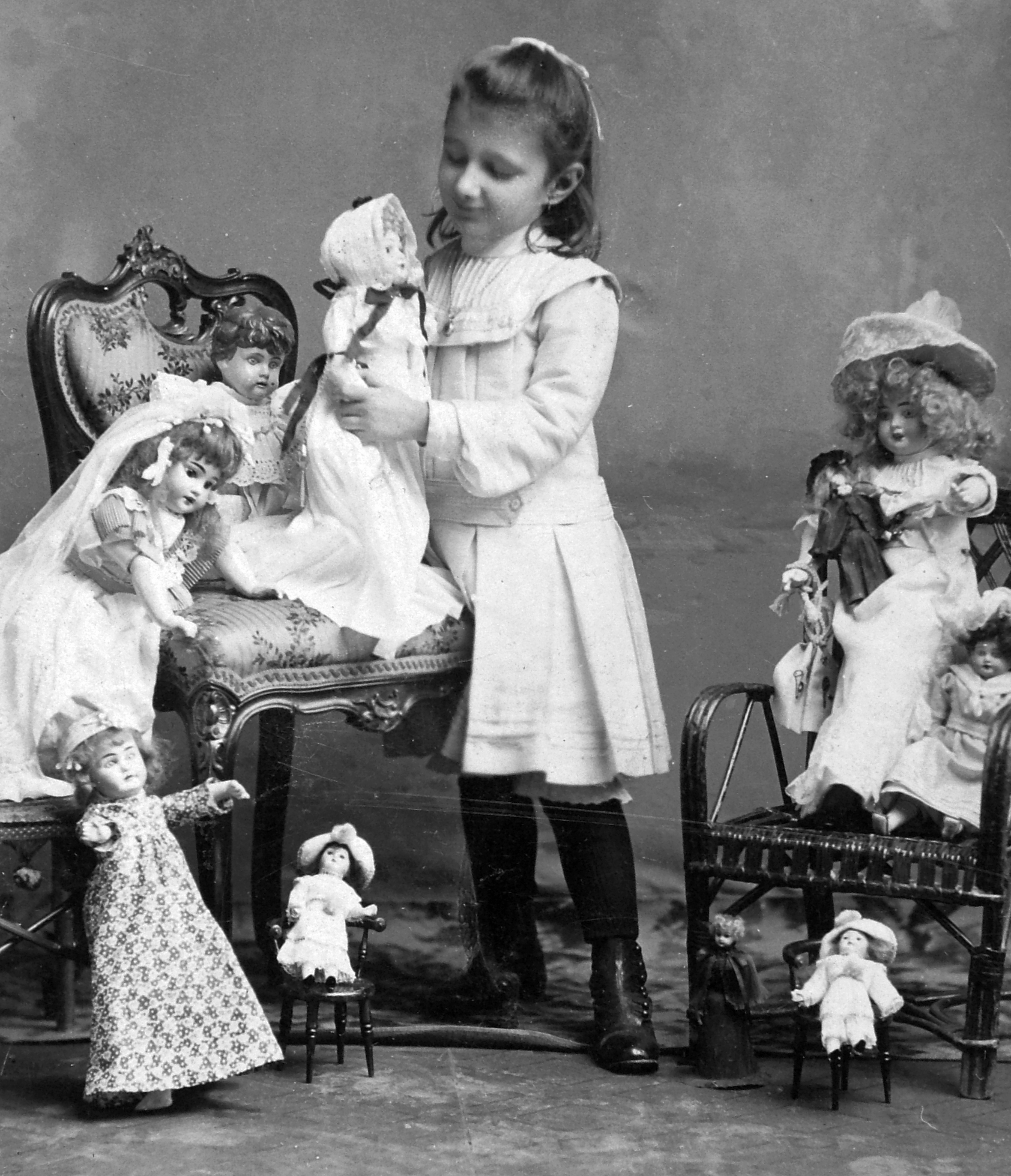 Kislány játékbabákkal fekete-fehér képen