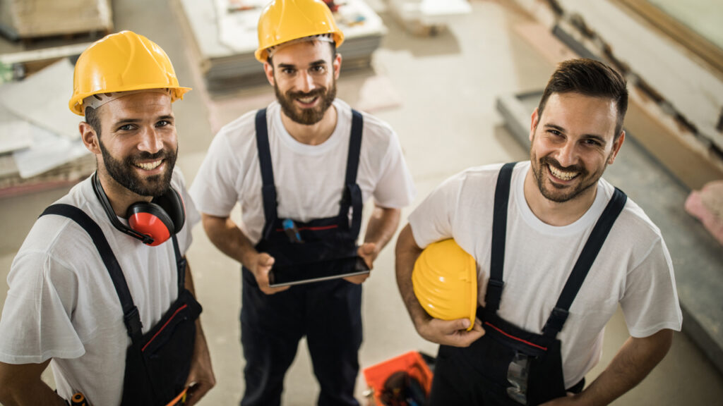 High angle view of happy construction workers during home renovation process looking at camera.