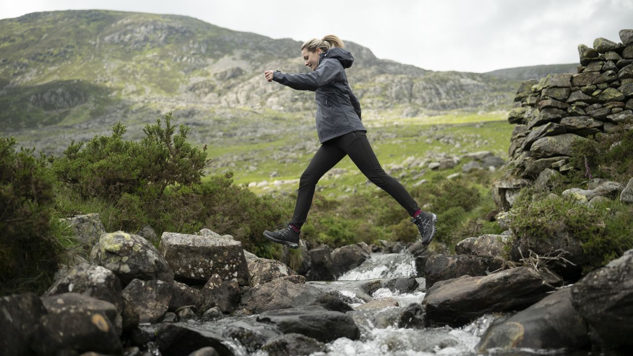 Lány lépked a hegyi patak fölött