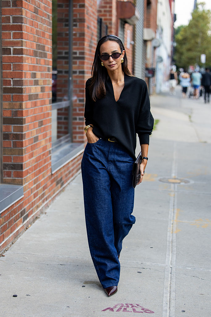 Sötétkék farmert viselő nő az utcán