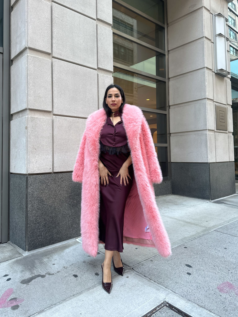 Burgundi-rózsaszín öltözéket viselő nő az utcán