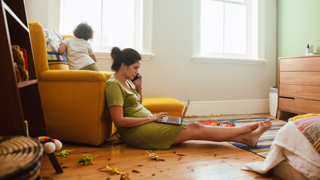 Anya dolgozik fia mellett otthon a földön ülve