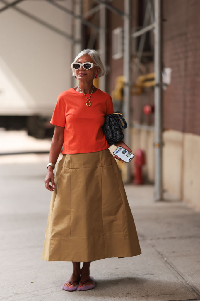 Korall és drapp öltözéket viselő nő az utcán