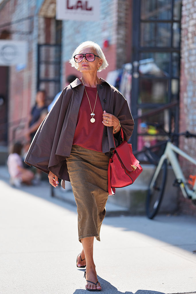 Meleg földszíneket viselő nő az utcán