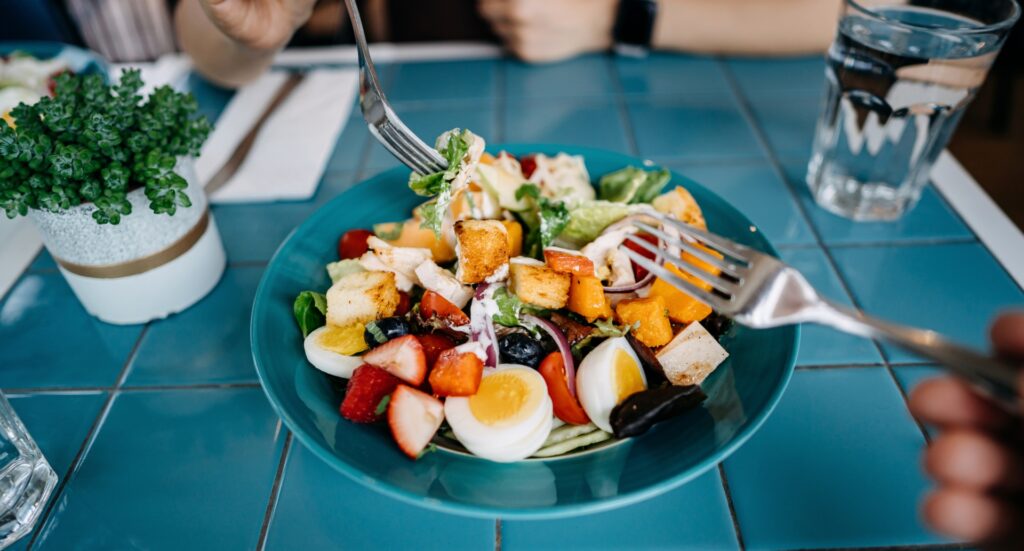 Színes saláta zöldségekkel, gyümölcsökkel, tojással