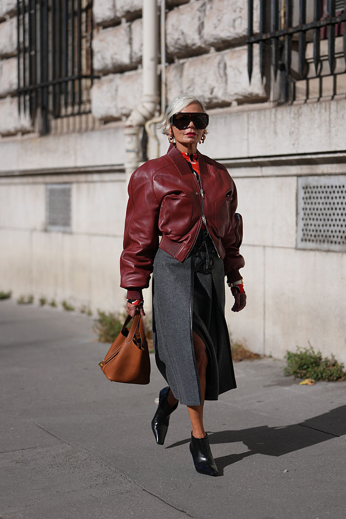 Szürke-burgundi öltözéket viselő nő az utcán